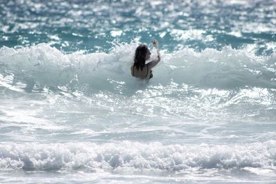 Rear view of woman swimming in sea