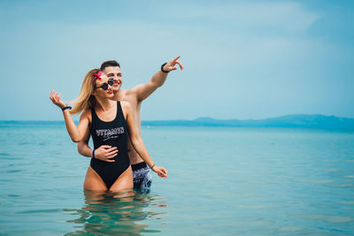 Young couple spending leisure time at beach against sky