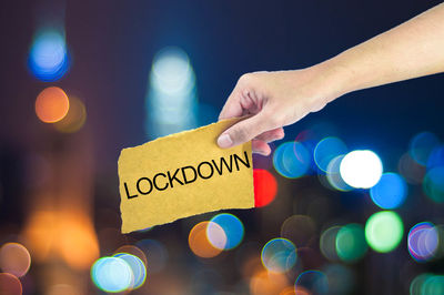 Close-up of hand holding illuminated text