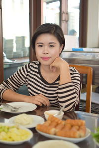 Portrait of woman sitting at restaurant table