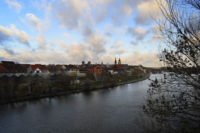 River amidst buildings in town against sky