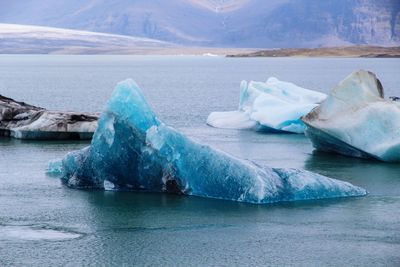 Scenic view of frozen sea against mountain