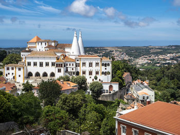 High angle view of townscape by sea against sky