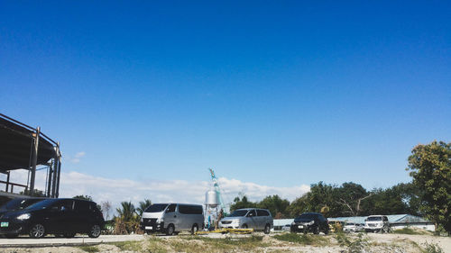 Cars on road against clear blue sky