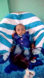 High angle view of baby girl lying on bed