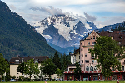 Houses by mountains against sky