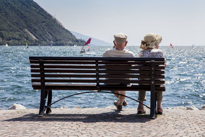 People sitting on shore against sea