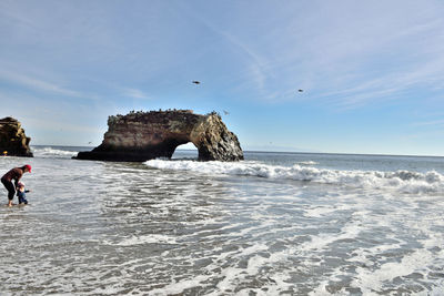 Scenic view of rocks on beach against sky