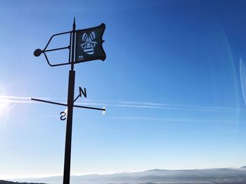 Low angle view of directional signs against blue sky