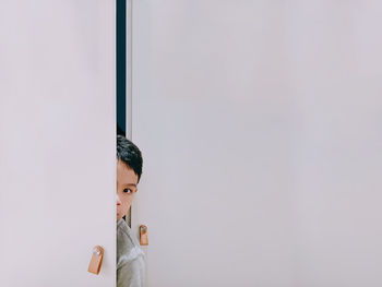 Portrait of young man against wall