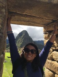 Portrait of smiling woman wearing sunglasses at old ruins