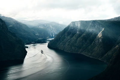 Scenic view of fjord amidst mountains against sky