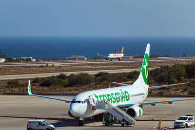 Airplane on runway against sky