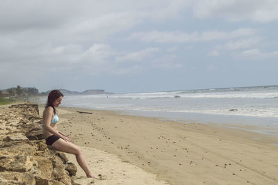 Woman on beach against sky