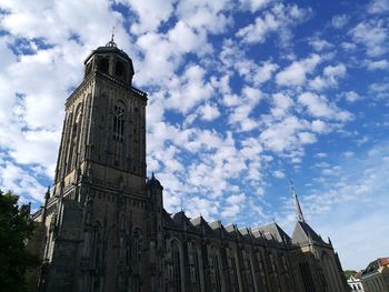 Low angle view of clock tower against cloudy sky