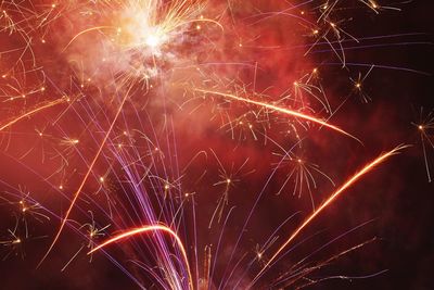 Low angle view of firework display against clear sky at night