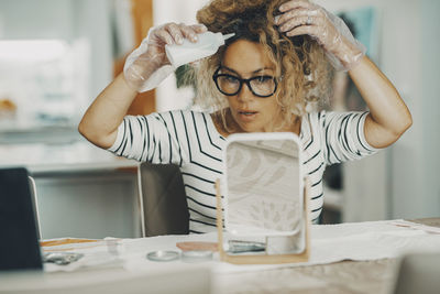 Portrait of young woman using mobile phone on table