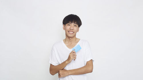 Portrait of smiling man standing against white background