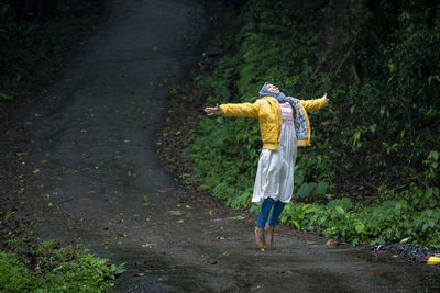 Full length rear view of man walking on road