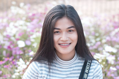 Close-up portrait of young woman smiling at park