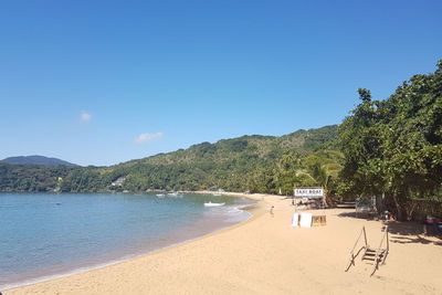 Scenic view of beach against clear blue sky