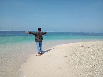 Full length rear view of man standing on beach