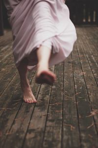 Low section of woman walking on boardwalk