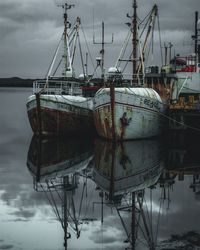 Fishing boat moored in sea against sky