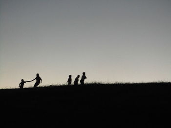 Silhouette people playing against sky