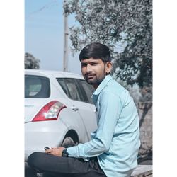 Portrait of young man sitting in car