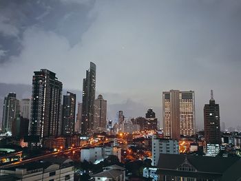 Illuminated buildings in city against sky at night