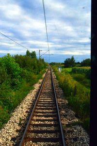 Railroad track against cloudy sky