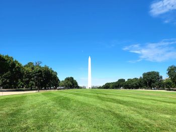 Scenic view of field against sky with the washington monument in the center on the field