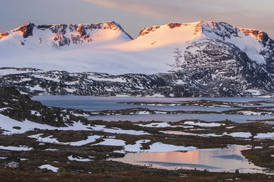 Scenic view of snowcapped mountains against sky during sunset