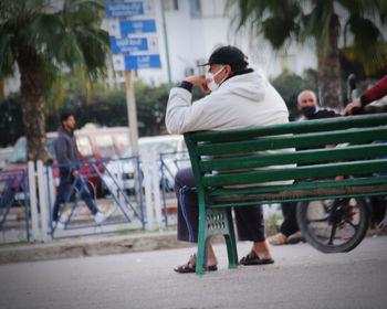 Rear view of people sitting on street in city