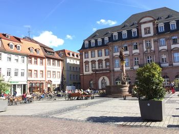 Buildings by street in city against sky