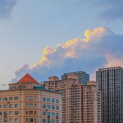 Low angle view of buildings against cloudy sky