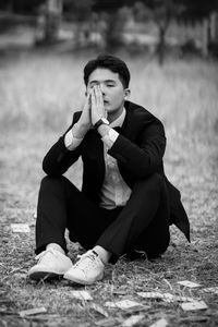 Young man sitting on field