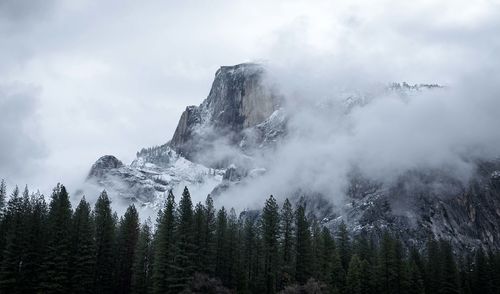 Scenic view of snowcapped mountains in foggy weather