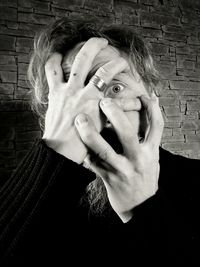 Portrait of woman hiding face with hands