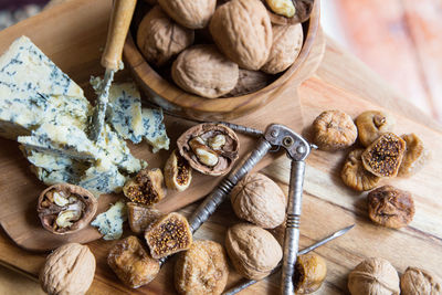 High angle view of dried fruits with cheese on cutting board