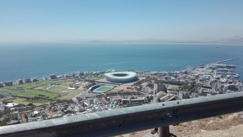 High angle view of town by sea against clear sky