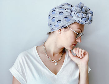 Portrait of young woman in neutral colors. candid millennial woman wearing african style headscarf. 