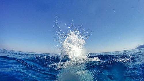 Wave splashing in sea against sky