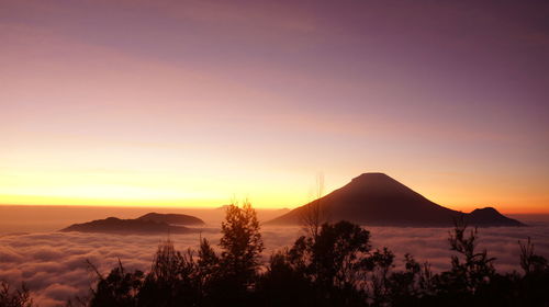 Scenic view of silhouette mountains against orange sky