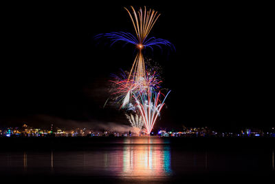 Firework display over river at night