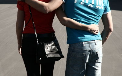 Midsection of friends walking on road