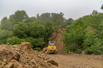 Working bulldozer clears area before construction. blue sky background