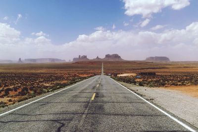 Empty road passing through field