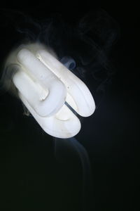Close-up of illuminated light bulb against black background